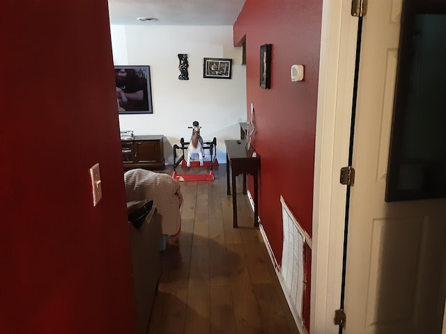 corridor with wood finished floors and visible vents