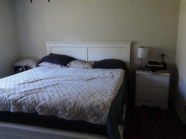 bedroom with dark wood finished floors