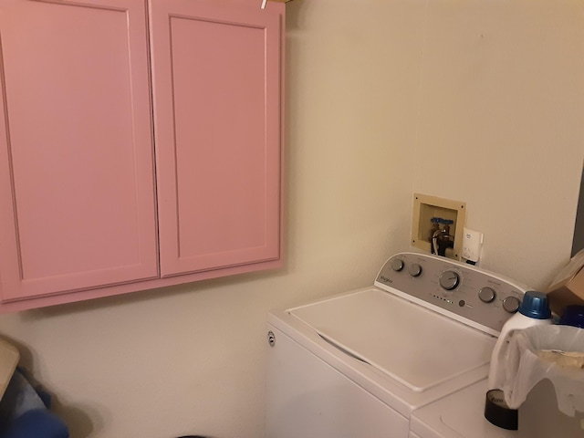 laundry room featuring washer and dryer and cabinets