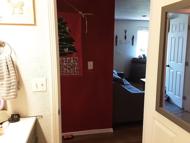 hallway with wood-type flooring and a textured ceiling