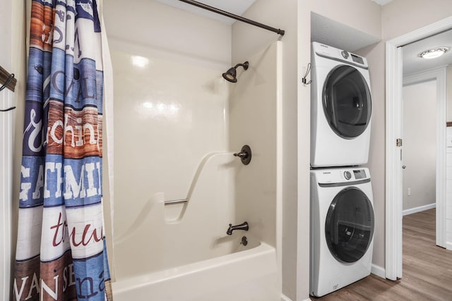 clothes washing area featuring stacked washer / dryer and wood-type flooring