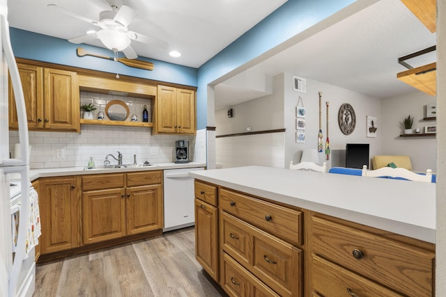 kitchen featuring backsplash, ceiling fan, light wood-type flooring, sink, and white appliances