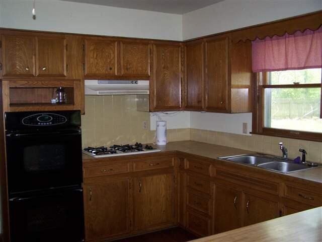 kitchen featuring white gas cooktop, black double oven, sink, and backsplash