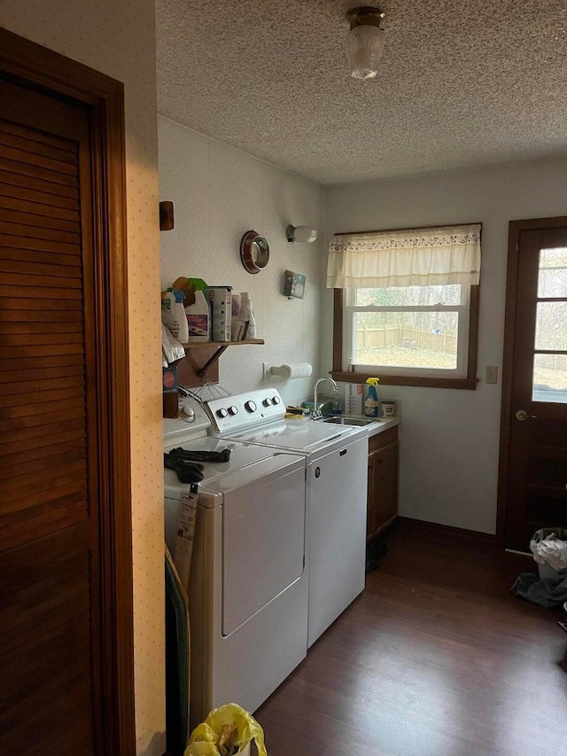 laundry area with sink, independent washer and dryer, a textured ceiling, cabinets, and dark hardwood / wood-style floors