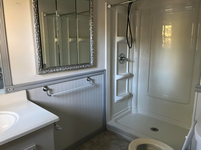 bathroom with vanity, tile patterned flooring, toilet, and walk in shower