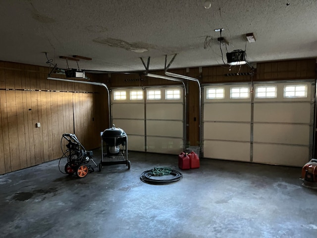 garage with wood walls and a garage door opener