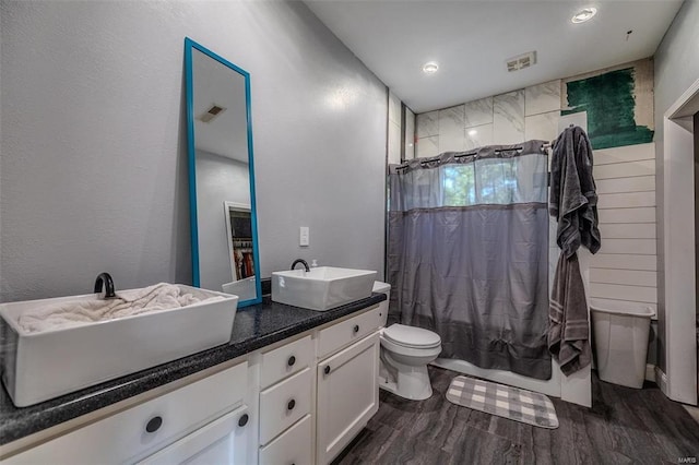 bathroom with toilet, curtained shower, vanity, and hardwood / wood-style flooring