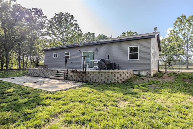 rear view of property featuring a patio area and a yard