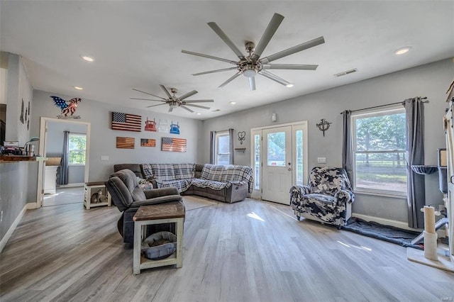 living room with light hardwood / wood-style floors, a healthy amount of sunlight, and ceiling fan