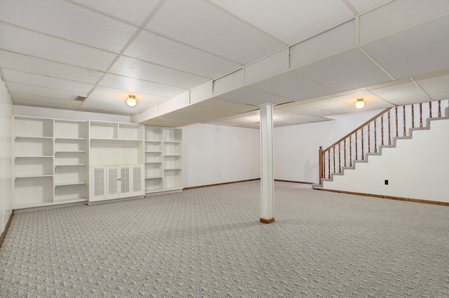 basement featuring a drop ceiling and carpet flooring