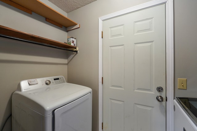 clothes washing area with independent washer and dryer and a textured ceiling