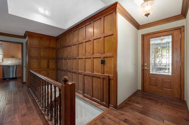 foyer with ornamental molding, a textured ceiling, and dark hardwood / wood-style floors