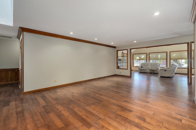 unfurnished living room with ornamental molding, a textured ceiling, a skylight, and dark hardwood / wood-style flooring