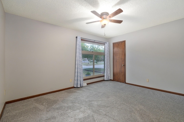 carpeted spare room featuring ceiling fan and a textured ceiling