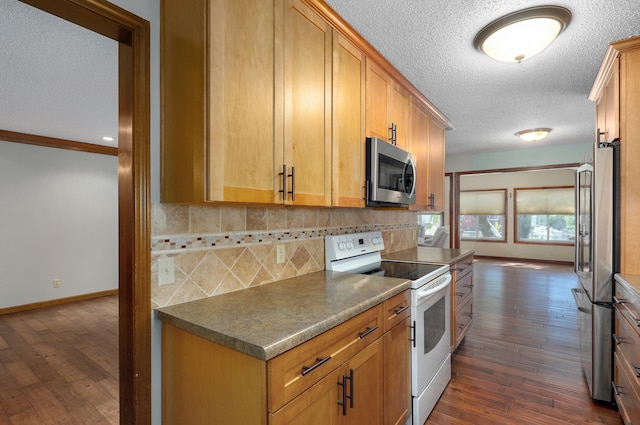 kitchen with ornamental molding, dark hardwood / wood-style floors, stainless steel appliances, and backsplash