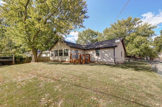 rear view of property featuring a deck and a lawn