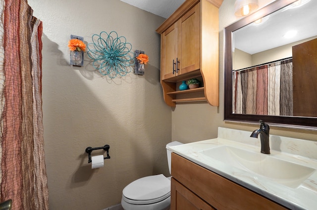 bathroom featuring toilet and vanity