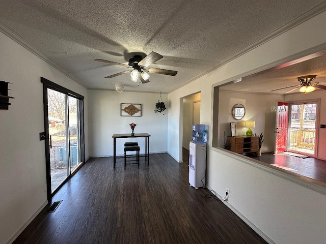 unfurnished dining area with ceiling fan, ornamental molding, dark hardwood / wood-style floors, and plenty of natural light