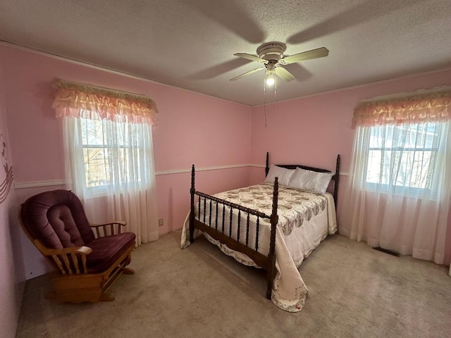 carpeted bedroom featuring a textured ceiling and ceiling fan