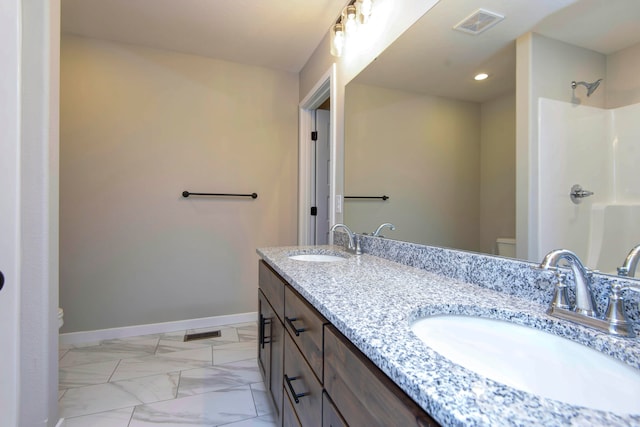 bathroom featuring vanity, toilet, and walk in shower