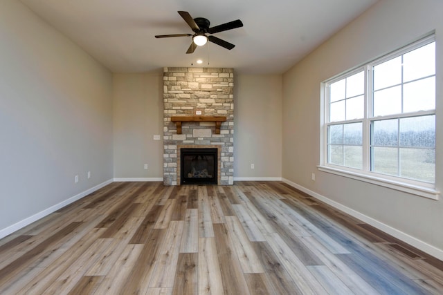 unfurnished living room with a fireplace, light hardwood / wood-style floors, and ceiling fan