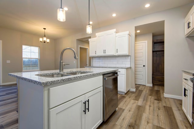 kitchen featuring white cabinetry, dishwasher, light stone countertops, sink, and an island with sink