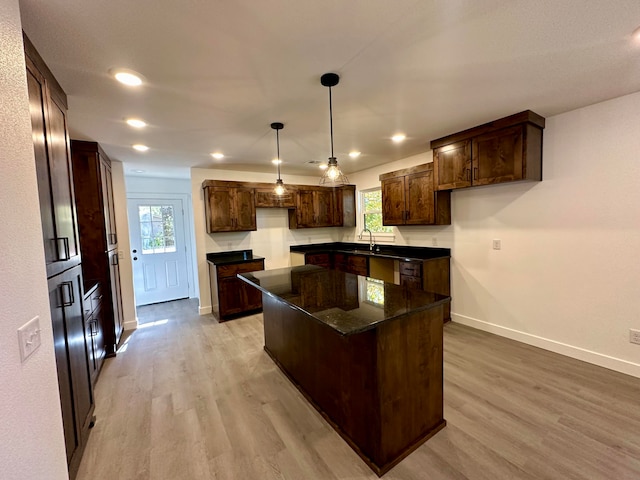 kitchen with light hardwood / wood-style flooring, hanging light fixtures, plenty of natural light, and a kitchen island