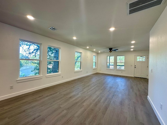 unfurnished room with ceiling fan, plenty of natural light, and dark hardwood / wood-style flooring