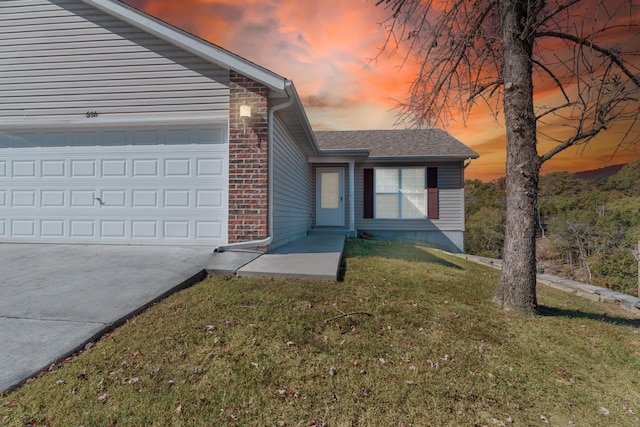 view of front of property featuring a yard and a garage