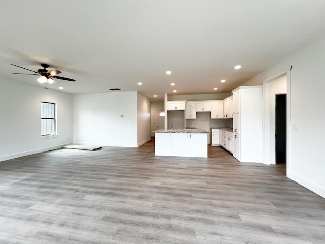 unfurnished living room featuring light wood-type flooring and ceiling fan