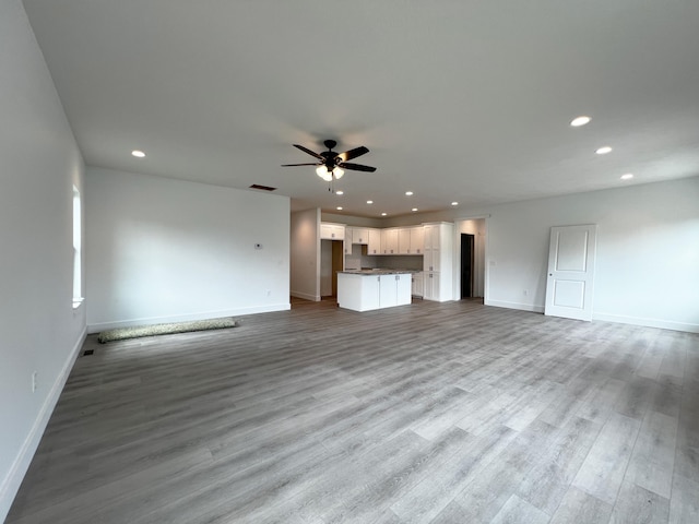 unfurnished living room with ceiling fan and light wood-type flooring