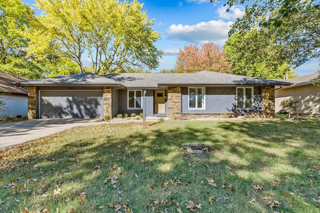 single story home featuring covered porch, a front yard, and a garage