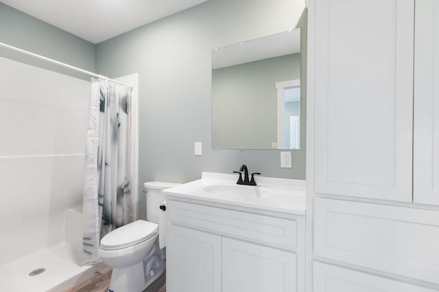 bathroom featuring curtained shower, hardwood / wood-style floors, vanity, and toilet