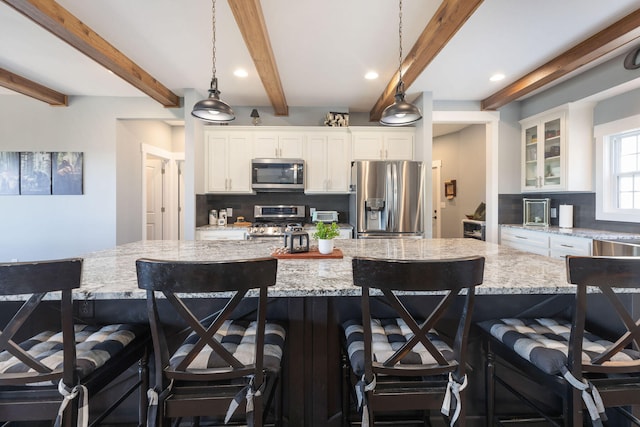 kitchen with a kitchen bar, stainless steel appliances, and a spacious island