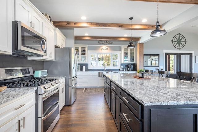 kitchen featuring a center island, hanging light fixtures, stainless steel appliances, dark hardwood / wood-style flooring, and white cabinets