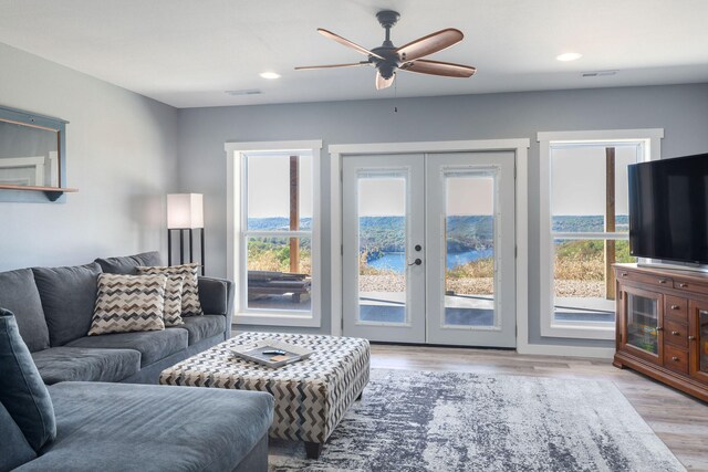 living room with french doors, light hardwood / wood-style floors, a wealth of natural light, and ceiling fan