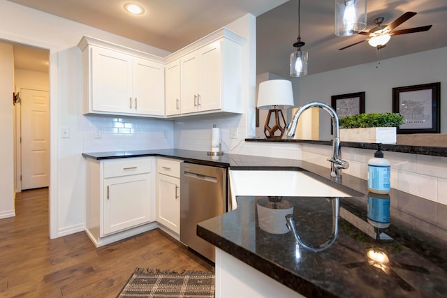 kitchen featuring dishwasher, wood-type flooring, dark stone countertops, sink, and white cabinets