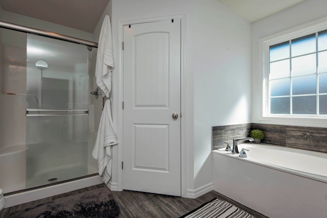 bathroom featuring plus walk in shower and wood-type flooring