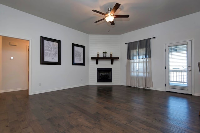 unfurnished living room featuring dark wood-type flooring and ceiling fan