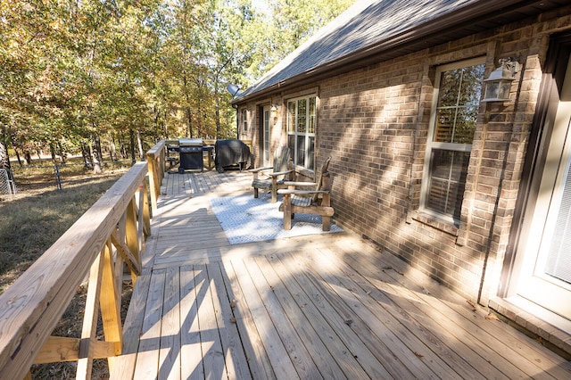 wooden deck featuring a grill