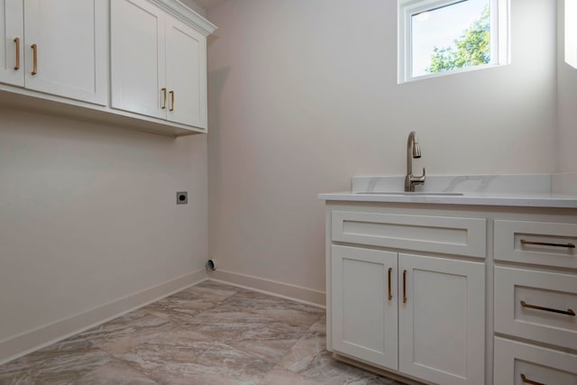 laundry area with sink, electric dryer hookup, and cabinets