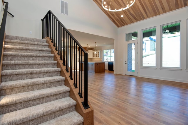 entrance foyer featuring wood ceiling, a chandelier, high vaulted ceiling, and light wood-type flooring