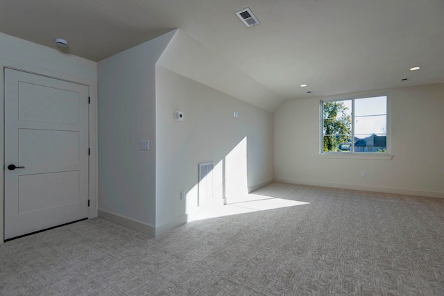 carpeted spare room featuring lofted ceiling