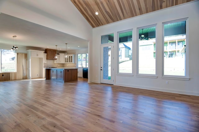 unfurnished living room featuring high vaulted ceiling, light hardwood / wood-style flooring, and plenty of natural light