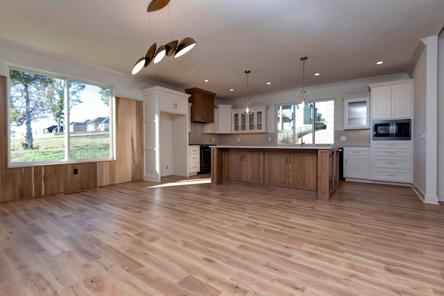 kitchen with light hardwood / wood-style floors, white cabinets, and a kitchen island