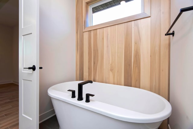 bathroom featuring a bath and hardwood / wood-style flooring