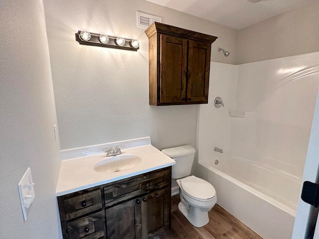 full bathroom featuring toilet, hardwood / wood-style floors, vanity, and  shower combination