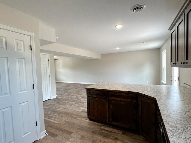 kitchen with dark hardwood / wood-style floors and dark brown cabinets