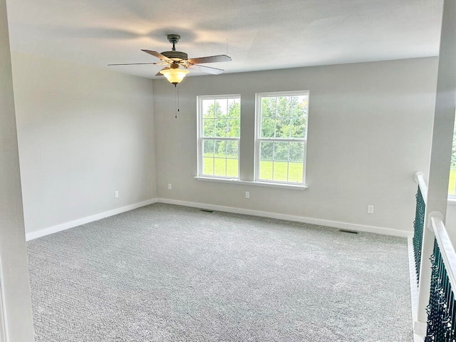 carpeted spare room with ceiling fan