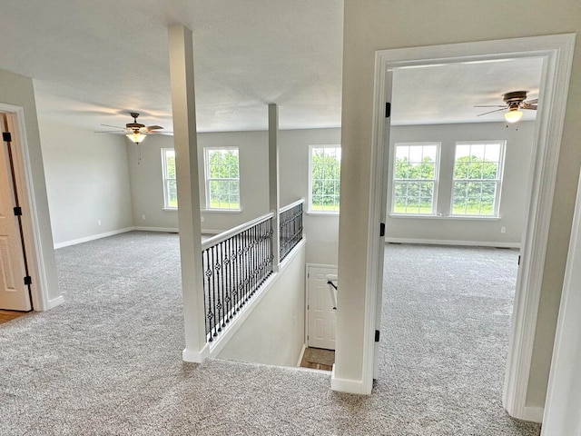 stairs with carpet floors, a healthy amount of sunlight, and ceiling fan